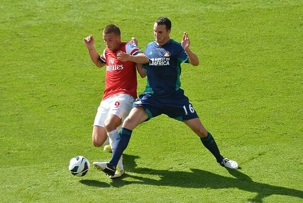 LONDON, ENGLAND - AUGUST 18: Lukas Podolski of Arsenal takes on John O Shea of Sunderland during the Barclays Premier League match between Arsenal and Sunderland at Emirates Stadium on August 18, 2012 in London, England. : Arsenal Football