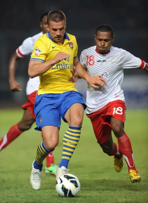 Framed Print : Lukas Podolski vs Yustinus Pae: Arsenal Star Clashes with Indonesia All-Star