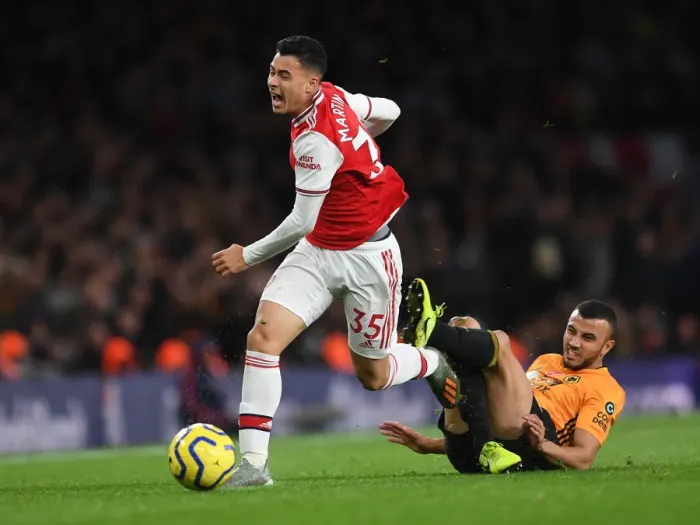 Framed Print : Martinelli Foul: Arsenal's Star Forward Halted by Saiss in Arsenal vs. Wolverhampton Clash (2019-20)