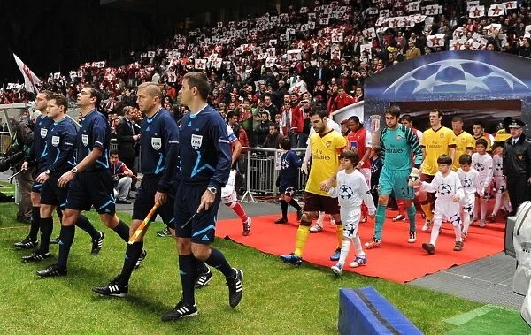 The match officials lead out the teams lead by Arsenal captain Cesc Fabregas