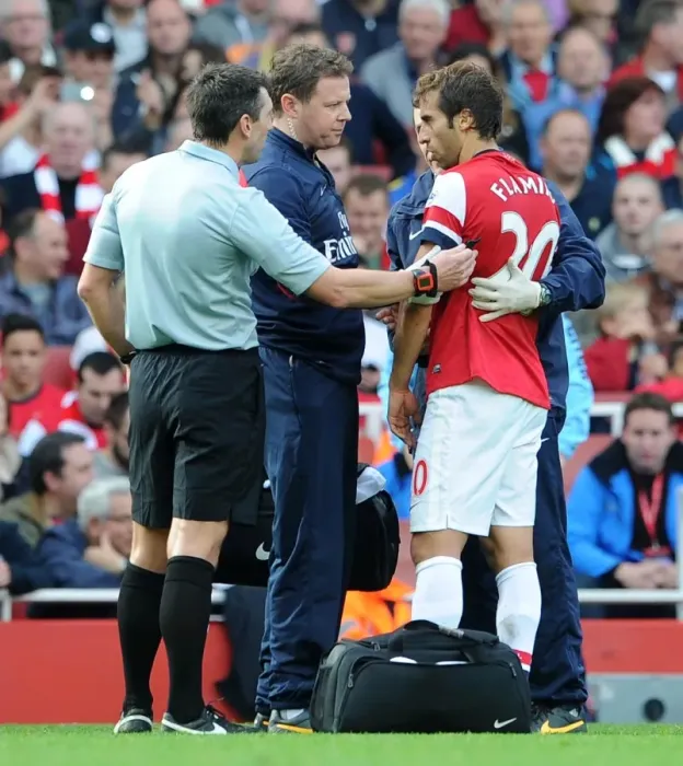 Framed Print : Mathieu Flamini (Arsenal) is checked by physio Colin Lewin following a clash of heads