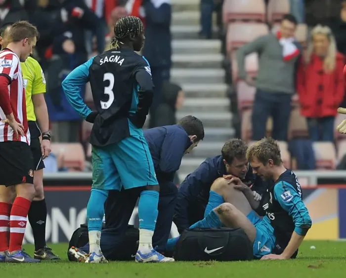 Framed Print : Per Mertesacker (Arsenal) is treated by Physio Colin Lewin. Sunderland 1: 2 Arsenal