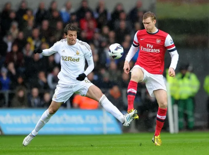 Framed Print : Per Mertesacker Fends Off Michu Pressure in Swansea City vs Arsenal Clash