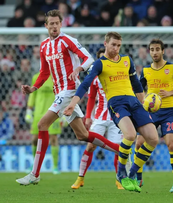 Framed Print : Per Mertesacker Fends Off Peter Crouch in Intense Stoke City vs. Arsenal Clash