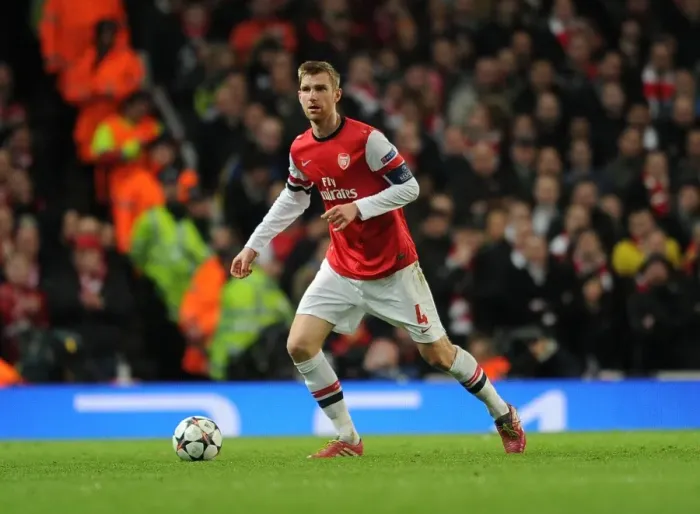 Framed Print : Per Mertesacker Focuses in Arsenal's UEFA Champions League Showdown against Bayern Munich