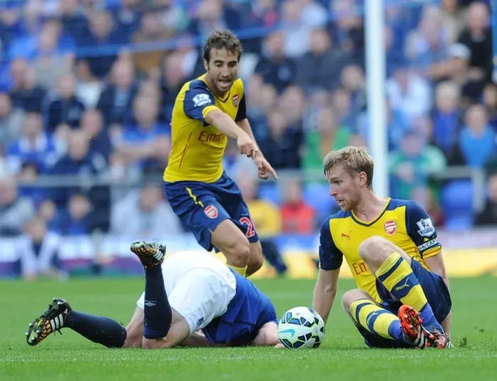 Framed Print : Per Mertesacker and Mathieu Flamini Challenge Steven Naismith in Intense Everton vs. Arsenal Premier League Clash