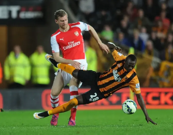 Framed Print : Per Mertesacker vs. Dame N'Doye: Intense Tackle in Arsenal's Victory over Hull City Framed Print : Per Mertesacker vs. Dame N'Doye: Intense Tackle in Arsenal's Victory over Hull City