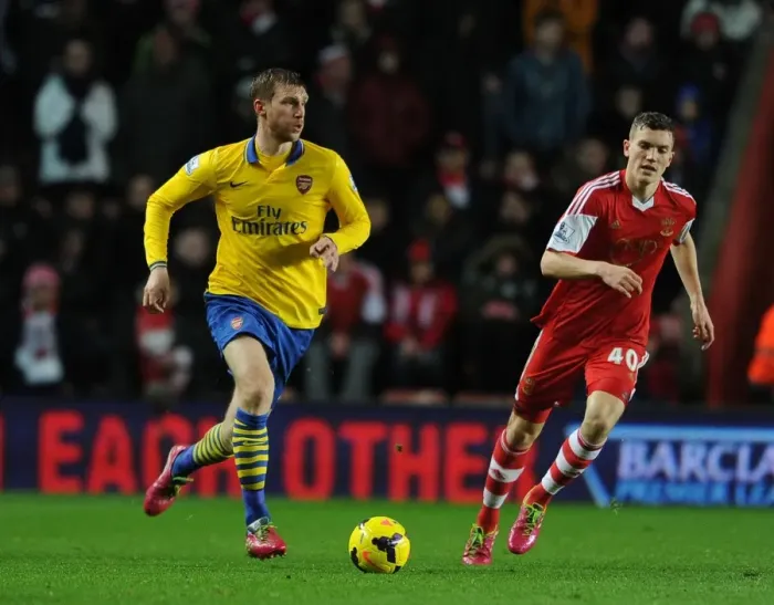 Framed Print : Per Mertesacker vs. Sam Gallagher: Intense Battle at Southampton's St Marys Stadium - Premier League 2013-14