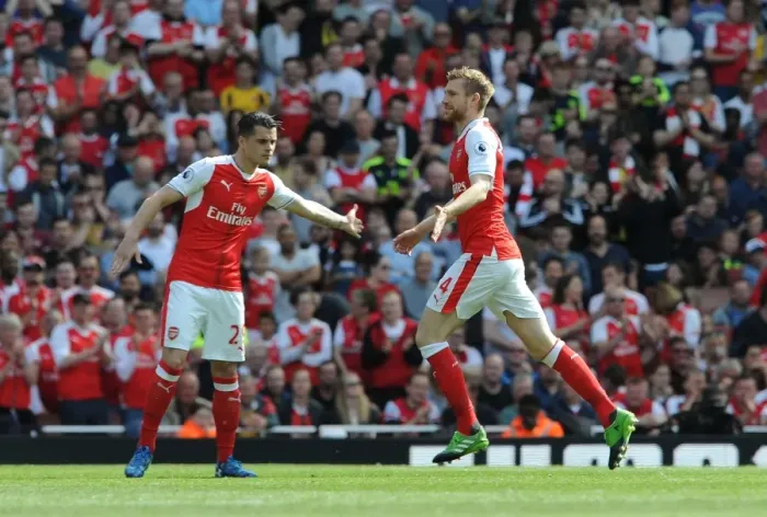 Framed Print : Mertesacker Welcomes Xhaka: A Moment of Camaraderie at Arsenal's Emirates Stadium