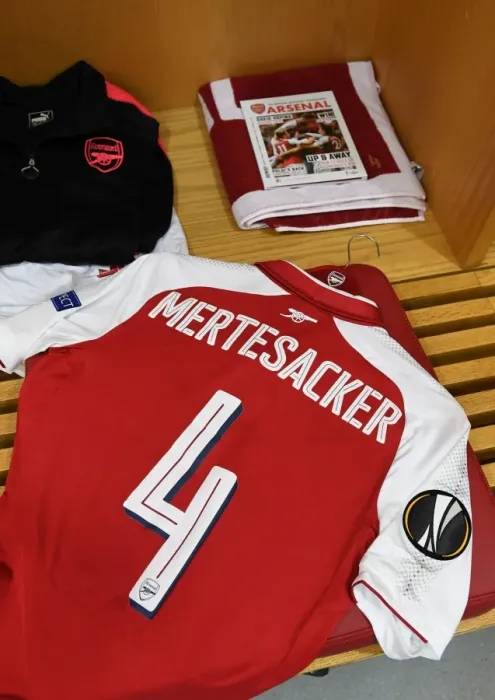 Framed Print : Per Mertesacker's Arsenal Shirt and Pennant in Arsenal's Changing Room (Arsenal v FC Köln, 2017-18)