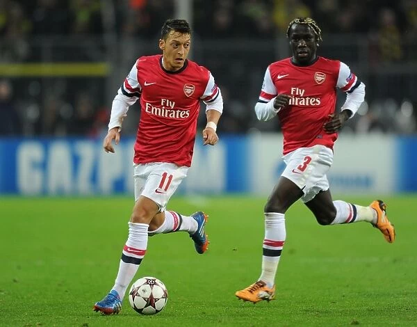 Mesut Ozil and Bacary Sagna of Arsenal Facing Off Against Borussia Dortmund in the 2013-14 UEFA Champions League