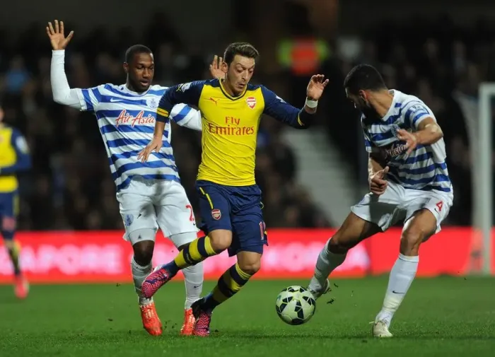 Framed Print : Mesut Ozil Clashes with Junior Hoilett and Steven Caulker during Queens Park Rangers vs Arsenal Premier League Match
