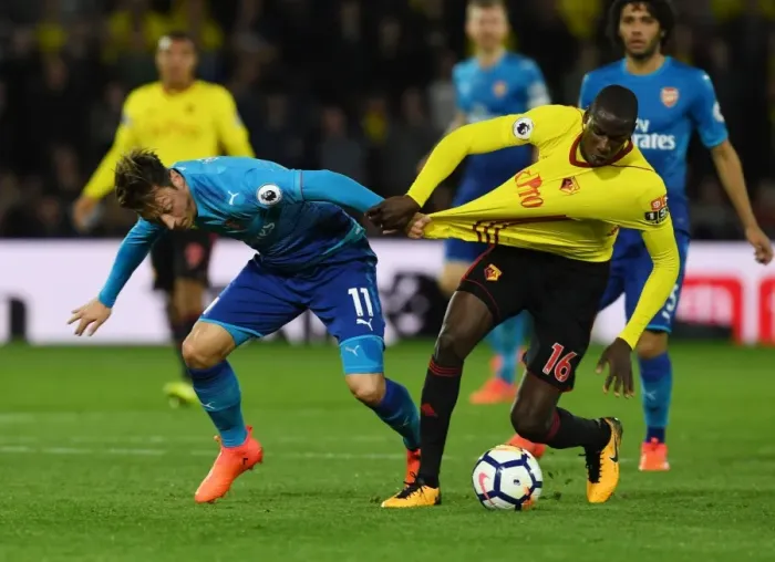Framed Print : Mesut Ozil vs. Abdouaye Doucoure: A Midfield Showdown at Vicarage Road