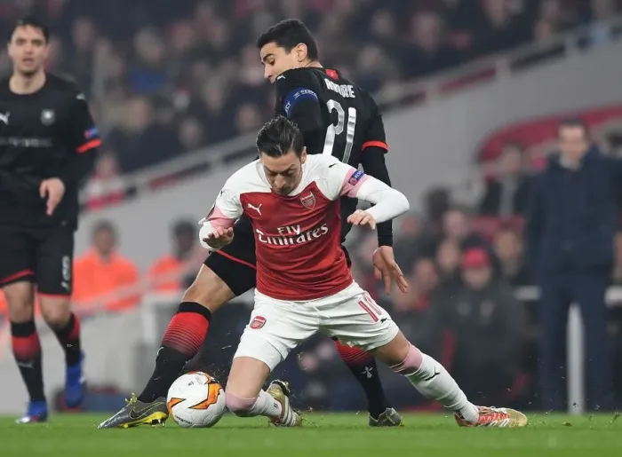 Framed Print : Mesut Ozil vs. Benjamin Andre: Clash in the Europa League Round of 16 between Arsenal and Stade Rennais Framed Print : Mesut Ozil vs. Benjamin Andre: Clash in the Europa League Round of 16 between Arsenal and Stade Rennais