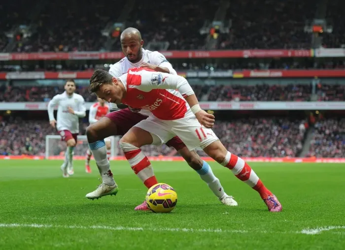 Framed Print : Mesut Ozil vs Fabian Delph: Intense Battle at Arsenal's Emirates Stadium (Arsenal v Aston Villa, 2014-15)