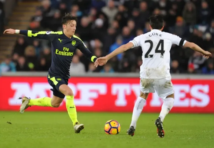 Framed Print : Mesut Ozil vs Jack Cork: Intense Battle in Swansea City vs Arsenal Premier League Clash Framed Print : Mesut Ozil vs Jack Cork: Intense Battle in Swansea City vs Arsenal Premier League Clash