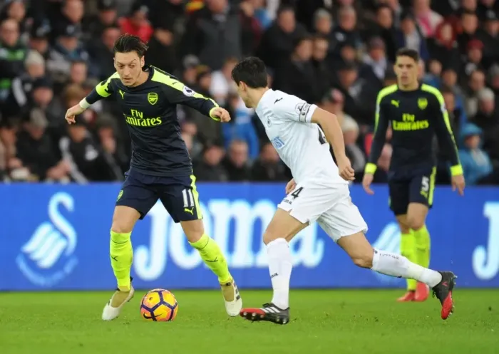 Framed Print : Mesut Ozil vs Jack Cork: A Premier League Showdown at Swansea City