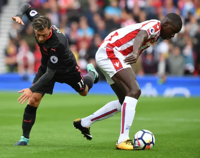Framed Print : Mesut Ozil vs Kurt Zouma: Intense Battle in Stoke City vs Arsenal Premier League Clash