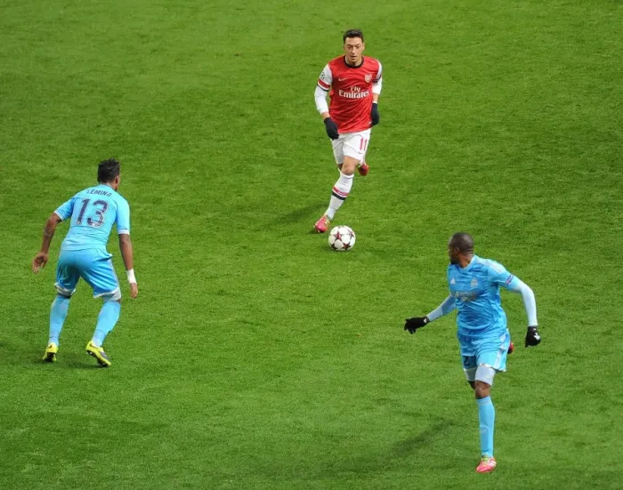 Framed Print : Mesut Ozil vs. Mario Lemina and Kassim Abdallah: Intense Battle at Arsenal v Marseille, UEFA Champions League (2013-14)