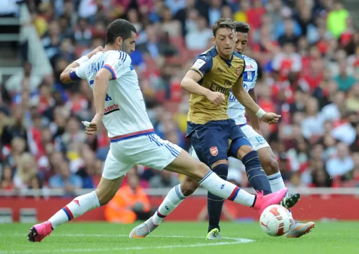 Framed Print : Mesut Ozil vs. Maxime Gonalons: A Tactical Showdown at the Emirates Cup