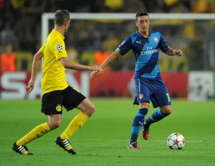 Framed Print : Mesut Ozil vs. Sven Bender: Intense Battle in Borussia Dortmund vs. Arsenal UEFA Champions League Clash