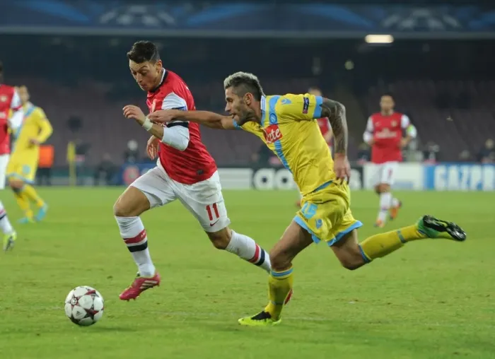 Framed Print : Mesut Ozil vs Valon Behrami: A Battle in the UEFA Champions League between Napoli and Arsenal