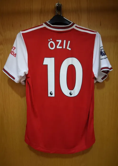 Framed Print : Mesut Ozil's Absence: An Empty Arsenal Jersey in the Home Changing Room vs. Wolverhampton Wanderers (2019-20)