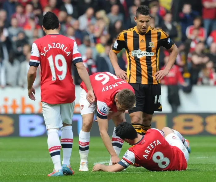 Framed Print : Mikel Arteta and Aaron Ramsey: Unusual Teamwork - Tooth Search on the Field (Hull City vs Arsenal, 2014)
