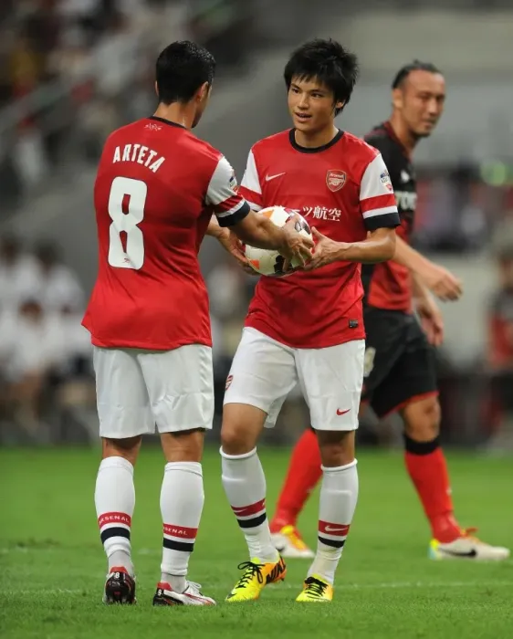 Framed Print : Mikel Arteta Assists Ryo Miyaichi in Pre-Season Penalty Shootout at Nagoya Grampus vs. Arsenal (2013)