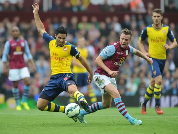 Framed Print : Mikel Arteta vs Tom Cleverly: Intense Clash in Aston Villa vs Arsenal Premier League Match, 2014