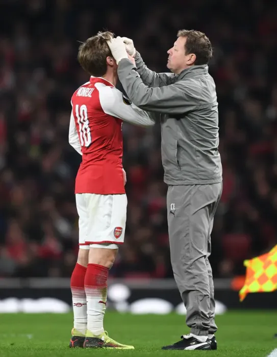 Framed Print : Nacho Monreal Receives Treatment from Arsenal Physio Colin Lewin during Arsenal v AC Milan Europa League Clash Framed Print : Nacho Monreal Receives Treatment from Arsenal Physio Colin Lewin during Arsenal v AC Milan Europa League Clash