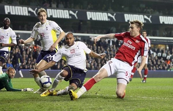Nicklas Bendtner scores Arsenals goal under pressure from Younes Kaboul (Tottenham)