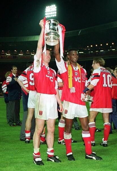 Nigel Winterburn and Paul Davis hold aloft the FA Cup Trophy after the game