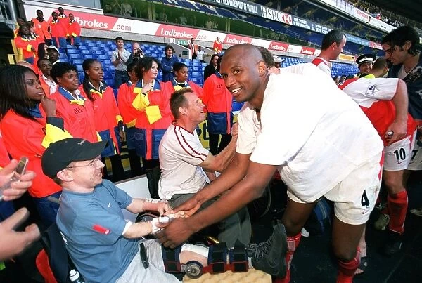 Patrick Vieira celebrates at the end of the match with a disabled fan