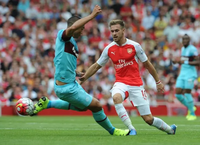 Framed Print : Ramsey Stands Firm: Arsenal's Midfielder Fends Off West Ham's Reid in Intense Premier League Showdown