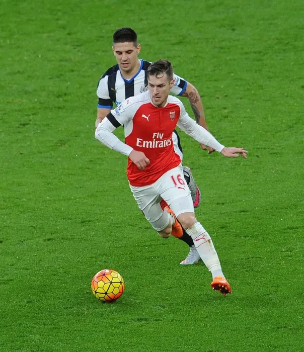Framed Print : Ramsey vs Mitrovic: Intense Clash between Arsenal's Midfielder and Newcastle's Striker in Premier League Showdown