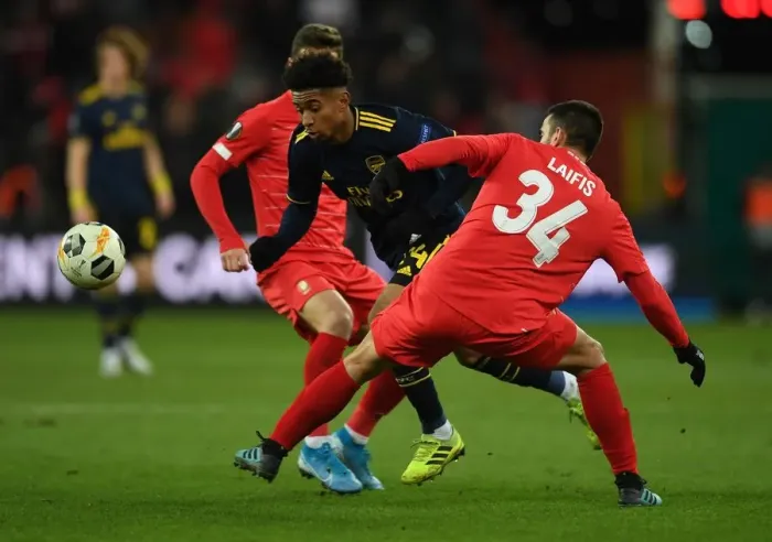 Framed Print : Reiss Nelson Darts Past Kostas Laifis: Arsenal's Europa League Battle at Standard Liege