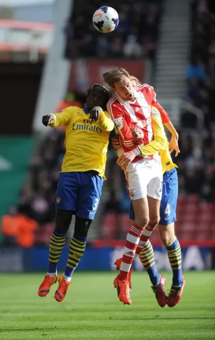 Framed Print : Sagna, Mertesacker and Crouch Clash in Stoke City vs Arsenal Premier League Encounter