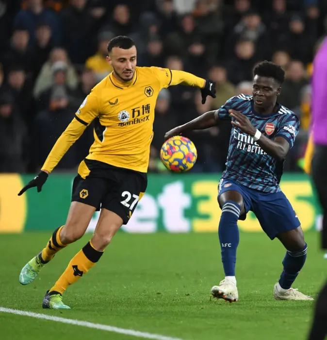 Framed Print : Saka vs. Saiss: Intense Battle in Wolverhampton Wanderers vs. Arsenal Premier League Clash