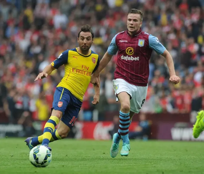 Framed Print : Santi Cazorla vs Tom Cleverley: Intense Battle in Aston Villa vs Arsenal Premier League Clash