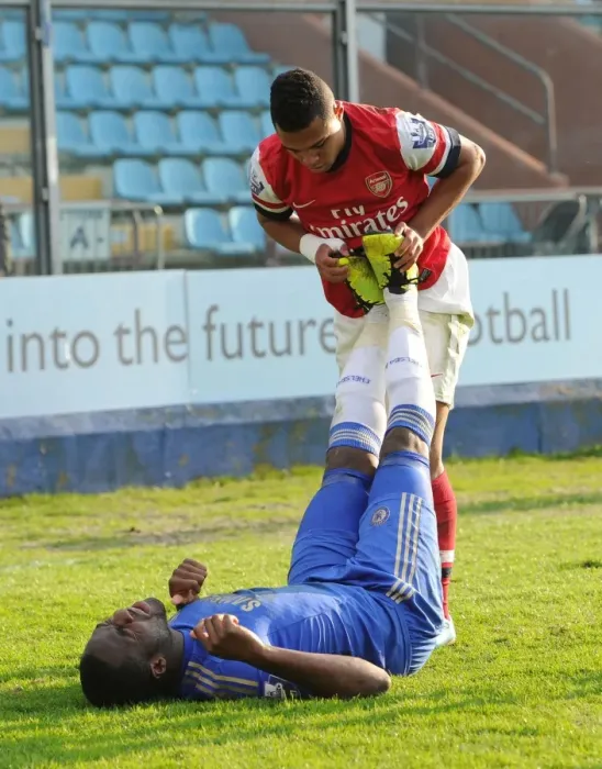 Framed Print : Serge Gnabry Shows Sportsmanship: Helping Injured Chelsea Player Danny Pappoe During Arsenal U19 vs Chelsea U19 NextGen Series Semi-Final