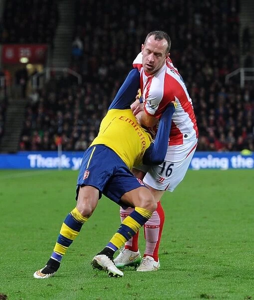 STOKE ON TRENT, ENGLAND - DECEMBER 06: Alexis Sanchez of Arsenal is fouled by Charlie