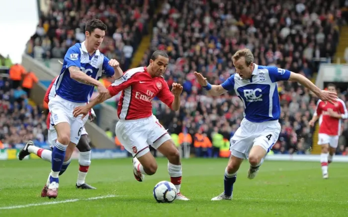 Framed Print : Theo Walcott Faces Off Against Birmingham Duo Liam Ridgewell and Lee Bowyer in Intense Barclays Premier League Clash