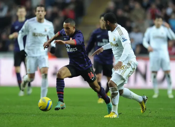 Framed Print : Theo Walcott Outmaneuvers Kemy Agustien in Swansea v Arsenal FA Cup Clash Framed Print : Theo Walcott Outmaneuvers Kemy Agustien in Swansea v Arsenal FA Cup Clash