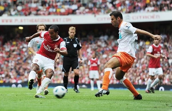 Theo Walcott shoots past Blackpool defender Dekel Keinan to score the 3rd Arsenal goal