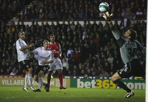 Theo Walcott shoots past Derby goalkeeper Roy Carroll to