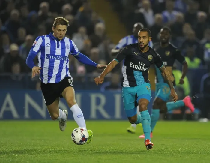 Framed Print : Theo Walcott vs. Glenn Loovens: A Battle of Wits in the Sheffield Wednesday vs. Arsenal Capital One Cup Clash