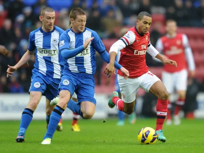 Framed Print : Theo Walcott vs. James McCarthy: Intense Battle in Wigan Athletic vs. Arsenal (2012-13) Framed Print : Theo Walcott vs. James McCarthy: Intense Battle in Wigan Athletic vs. Arsenal (2012-13)