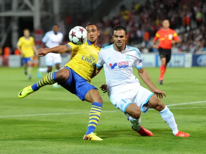 Framed Print : Theo Walcott vs. Jeremy Morel: A Tense Moment in the Marseille vs. Arsenal UEFA Champions League Clash