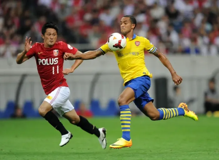 Framed Print : Theo Walcott vs. Kunimitsu Sekiguchi: A Battle for Ball Possession in Arsenal's 2013 Pre-Season Clash with Urawa Red Diamonds